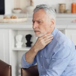Man holding his sore throat